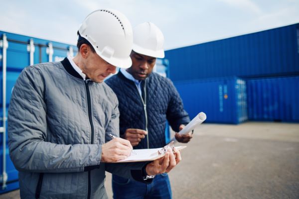 Estudio Hidrológico 4; dos ingenieros viendo los planos de un proyecto.