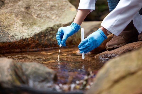 Ingeniería hidrológica; Científico con muestra de agua para inspección, investigación y estudio de ecosistemas.