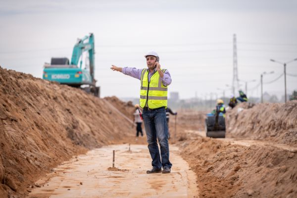 Estudio geohidrológico; ingeniero de construcción usa un uniforme de seguridad durante la inspección.