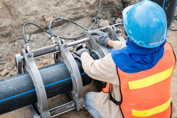 Diseño hidráulico; hombre revisando el funcionamiento de tubos para tránsito de agua